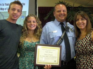 Jose Labrador displays his award for valor. With him are his wife Olivia and their children Donovan and Dominique.
