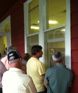 Members of the crowd who could not fit inside at the Casino building in Fruitland Park, peer in through the windows.