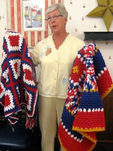 Louise Fahey of Busy Hands Happy Hearts shows lap robes donated for the veterans for the Nov. 2 Honor Flight.
