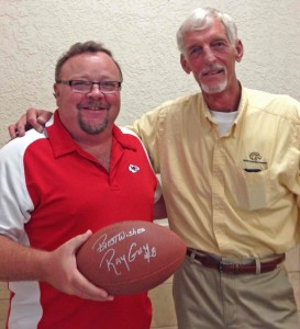 Dan Magathan, left, of the Village of Country Club Hills, shows off the  football autographed by NFL legend Ray Guy, right.