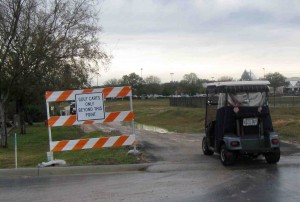 A golf cart enters a dirt path along U.S. Hwy 27/441 that serves as a lifeline for golf-carting Stonecresters.