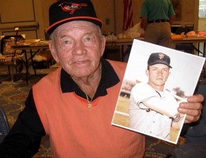 Jackie Brandt holds a photo of himself from his playing days. 