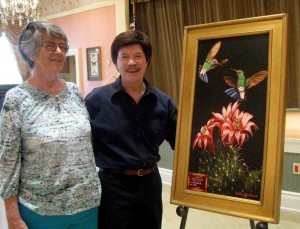 Barbara Bohm, left, admires a piece of Bobby Goldsboro's artwork. Her husband wound up buying it for her.