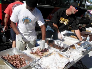 Napolean McCoy, left, and Brad Becker chop up meat for the Properties of The Villages barbecue station at the 13th Annual BBQ Bash Saturday at Spanish Springs Town Square.