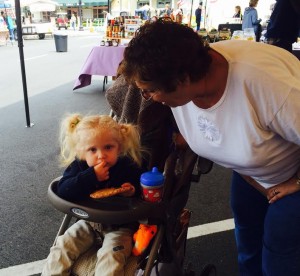 Village of Palo Alto resident Rita Goodhelps great-granddaughter, Sophia, with a homemade cookie at the Spanish Springs Farmers Market.