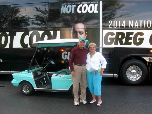 Don and Leslie Kaiser pose with their golf cart in front of Greg Gutfeld's tour bus. 
