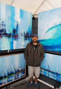 Artist Miguel Ruiz with his large semi-abstract seascape paintings.