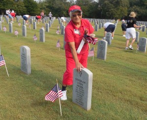 Villager Bella Kulick places flags at graves at Florida National Cemetery in Bushnell.  