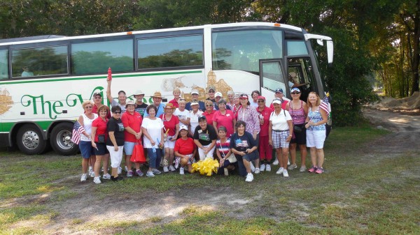 Villagers who went to Florida National Cemetery pose in front of a bus donated by Villages Transportation.