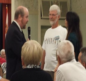 A detective, played by actor John Maynard, questions suspects Renzo Ganassini and Catherine, played by actress Kristie Fontelera.