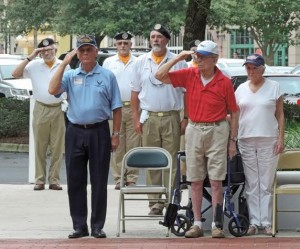Don Chaplin, in red shirt, salutes during the ceremony. 