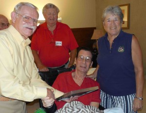 Don Deakin, left, presents Rich Lambrecht with a resolution of appreciation in September, as John Regule and Elaine Dreidame look on.