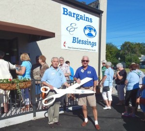 Project co-chairs Bob Becker and Gene Barton pose with the ribbon-cutting scissors outside the newly dedicated store.