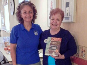 Joyce Edmonds, showed Claudia Labbe the cookbook with club members' personal recipes.