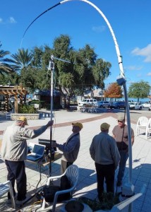 Leon Jurszyszyn and Bob Hagan set up a tall, curving metal antenna.