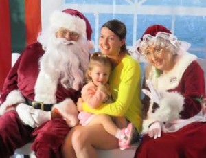 Honey Wamsley sits with mother Sarah and Santa and Mrs. Claus.