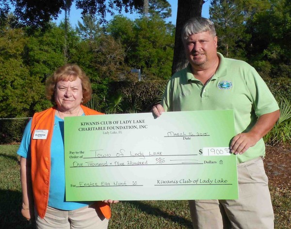 Kiwanian Glendia Brown presents a $1,900 check to Mike Burske.