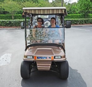 Addie Bross drives a golf cart with her grandmother, Jane Janes, riding shotgun.