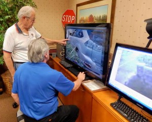 Carl Bell, standing, looks at an image from one of the gate cameras.