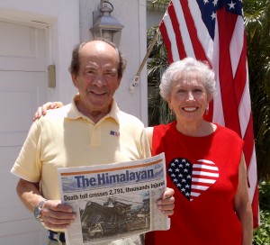 Ted Godlin holds a copy of a newspaper from Nepalwith news of the earthquake. His wife, Kelley Kaufman, is at right.