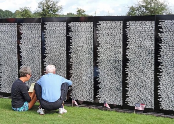 A couple looks for a name on the Traveling Vietnam Memorial Wall.