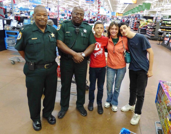 Nehemiah Wolfe, left, and Deputy Woolfork shop with the Fruci famly.