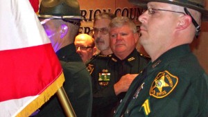 Sheriff Chris Blair looks at the American flag during an honor guard presentation Thursday night.