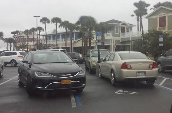 A car at Publix at Brownwood overlaps onto a handicapped parking spot.