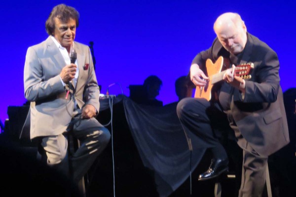 Johnny Mathis and guitarist Gil Reigers perform on stage.