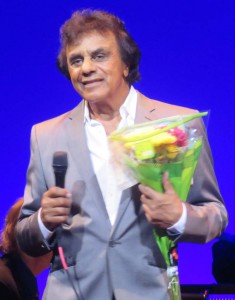 Johnny Mathis takes a curtain call with flowers from a Villager.