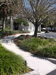 A sidewalk connects the postal station to the parking lot.