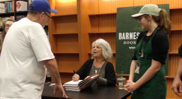 Paula Deen talks to a fan while autographing his book.