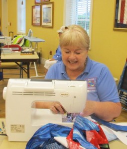 Ardie Wood performs a demo of the lap blankets they make for the Honor Flight program.