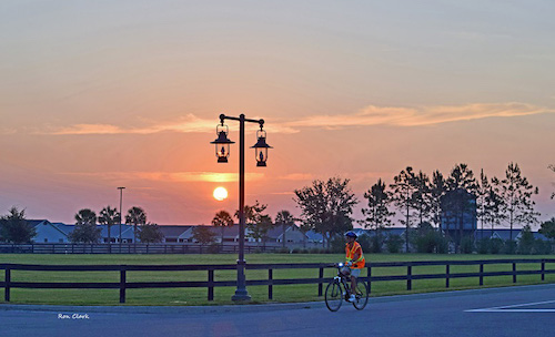 Cyclist riding in Brownwood at sunrise in The Villages