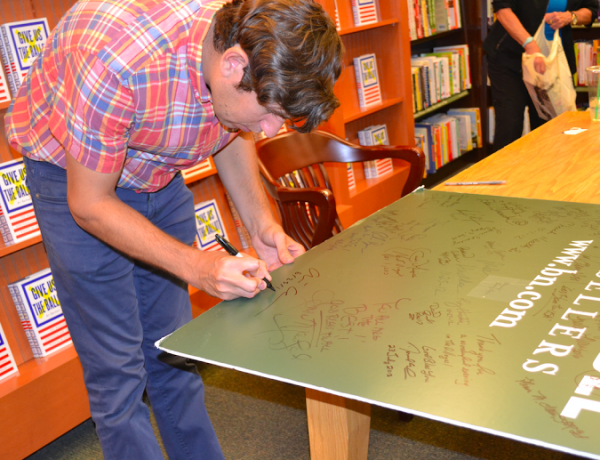 Ari Berman adds his signature to a Barnes & Noble poster.