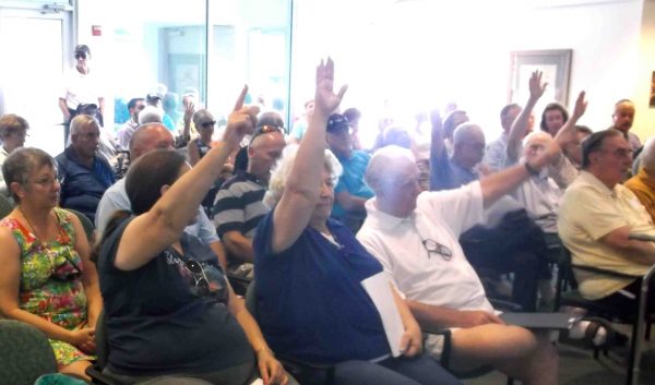 Those opposed to the proposed indoor gun range raise their hands Monday night at a Lady Lake Commission meeting.