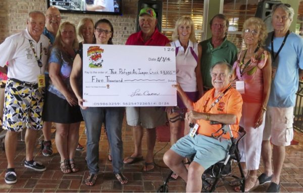 Amber Tucker, Community Relations Trustee Steve Larson, and Charity Committee member Thurman Shurtleff holding the “Big Check,” plus Club President Lee Caron and the members of the charity committee.