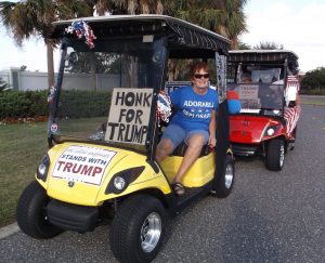 Marie Reinle leads the Donald Trump golf cart rally on Friday.