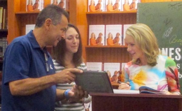 Dana Perino with Joe Miraglia and Jacki Lembeck looking at pictures of their Jasper.