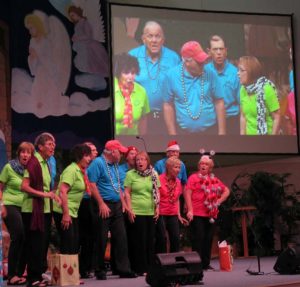 The A Cappella Gold singing group sings under a video screen at the North Lake Presbyterian Church.