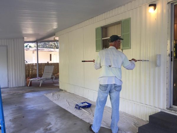 Rotary Club member Rex Dugan painting front of the home.