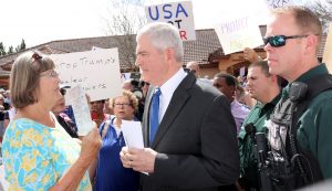 A deputy accompanied Congressman Daniel Webster as he walked through the crowd.