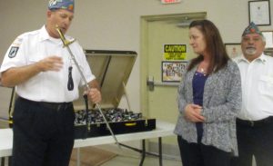 Adjutant Doug White showing the officer sword to Maria Watke with Commander Bill Preston.