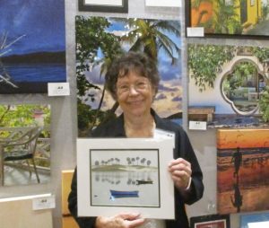 Artist Betty Eich holding a print of her award winning work she donated to the scholarship fund.