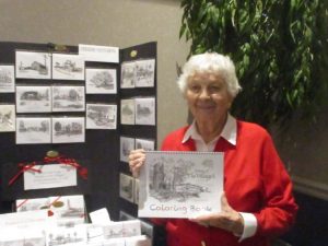 Artist Freddie Venturoni holding her adult coloring book filled with her award winning pen and ink drawings.