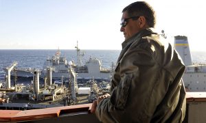 Capt. David Lausman in 2010 watches the Military Sealift Command's Fleet Replenishment Oiler USNS Tippecanoe as it transfers fuel to USS Cowpens and George Washington during a replenishment at sea. 
