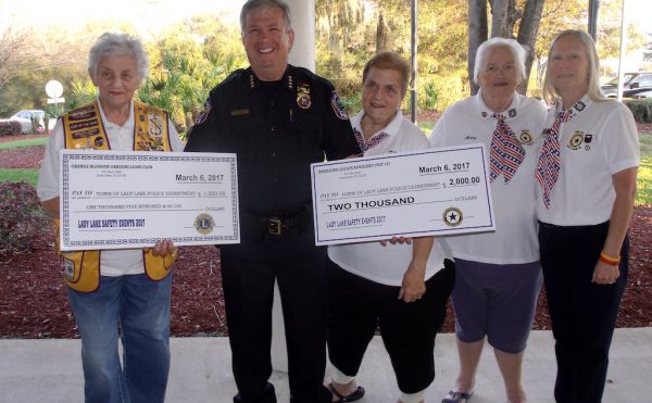 Police Chief Chris McKinstry accepted checks Monday evening from the Orange Blossom Gardens Lions Club and the American Legion Auxiliary.