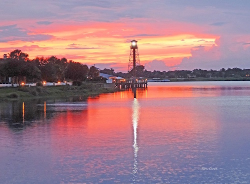 Sunset behind a lit lighthouse at Lake Sumter Landing