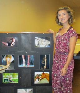 Angelica Brown standing next to her stunning photography display.