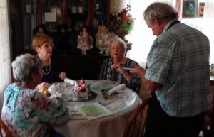 John Bennett takes an order at Polly's Tearoom from Villager Nancy Crossan far right and her friends.